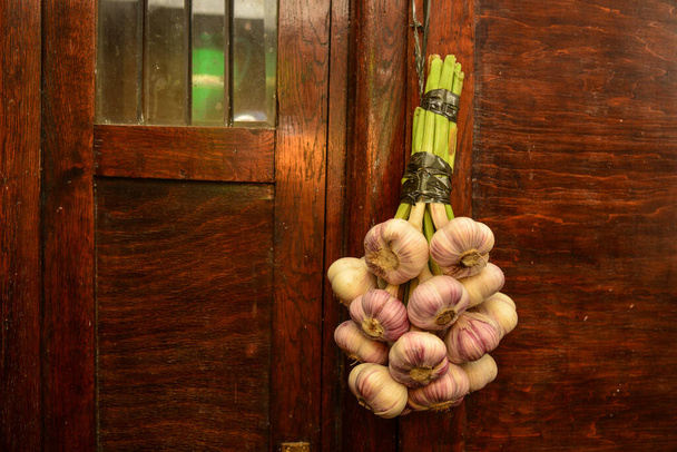 Harvest. Bunches of garlic are dried in a barn in the village. - Photo, image