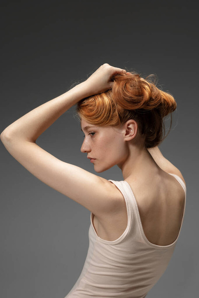 Portrait of beautiful redhead woman isolated on grey studio background. Concept of beauty, skin care, fashion and style - Fotó, kép
