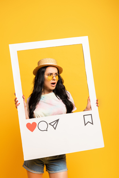 shocked brunette girl in summer outfit posing in social network frame on yellow background - Photo, Image
