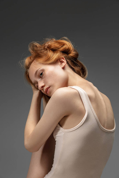Portrait of beautiful redhead woman isolated on grey studio background. Concept of beauty, skin care, fashion and style - 写真・画像