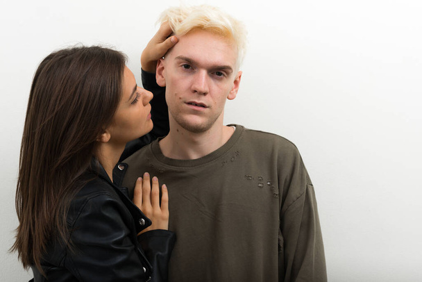 Studio shot of young blond man and young beautiful woman as couple together against white background - Photo, Image