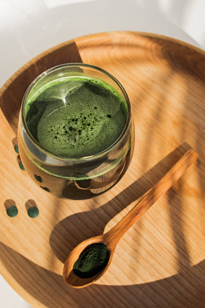 Spirulina or chlorella in a glass. Green food supplement, healhy lifestyle. - Photo, Image
