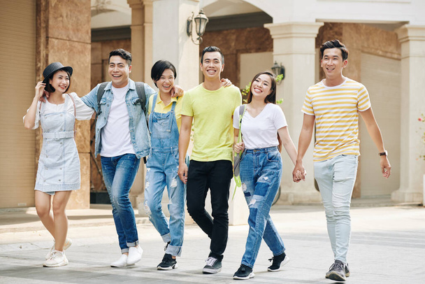 Grupo de jovens asiáticos felizes andando na rua no dia ensolarado
 - Foto, Imagem