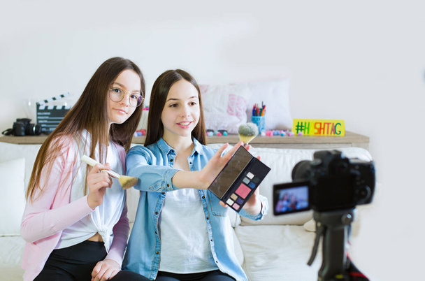 Kaksi teini tyttöjen bloggaaja esittelee kauneustuotteita ja lähettää live-videon sosiaalisille verkostoille. Keskity teinityttöjen vaikuttajiin. Kauneus bloggaaja ja vlog käsite. - Valokuva, kuva