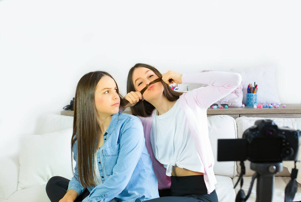 İki genç kız blogcu eğleniyor ve sosyal ağlara canlı yayın yapıyorlar. Genç blogcu kızların etkilerine odaklan. Güzellik blogcusu ve vlog konsepti. - Fotoğraf, Görsel