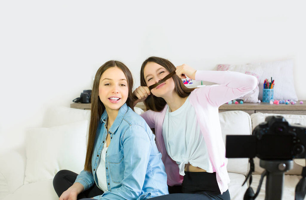İki genç kız blogcu eğleniyor ve sosyal ağlara canlı yayın yapıyorlar. Genç blogcu kızların etkilerine odaklan. Güzellik blogcusu ve vlog konsepti. - Fotoğraf, Görsel