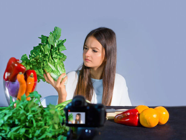 La blogueuse adolescente parle aux adeptes des avantages de manger des fruits et légumes biologiques. Concept de communication aux adolescents par un jeune influenzer des avantages sur le bien-être en raison d'un mode de vie sain et d'une alimentation saine - Photo, image
