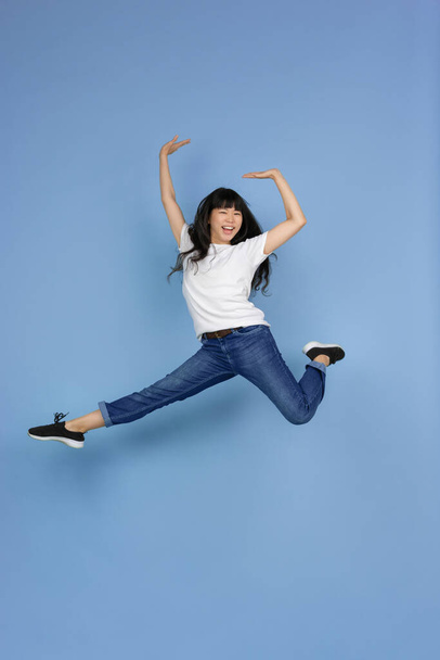Portrait of young asian woman isolated on blue studio background - Photo, image