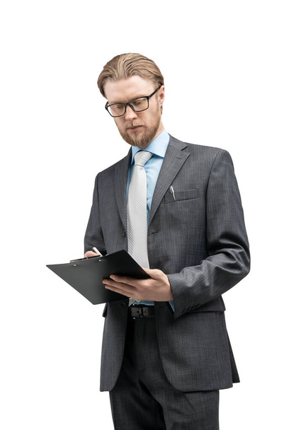 vertical portrait one man businessman or office-worker in glasses spectacles, stand with notebook and writes, on white background, isolated - Valokuva, kuva