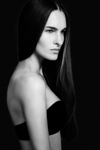 Young woman with pretty long hair looking away - Foto, afbeelding