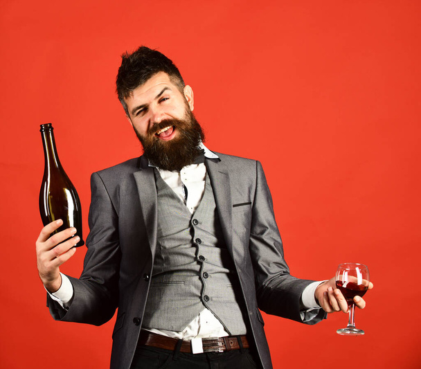 Degustator with beard and expensive wine on red background - Фото, изображение