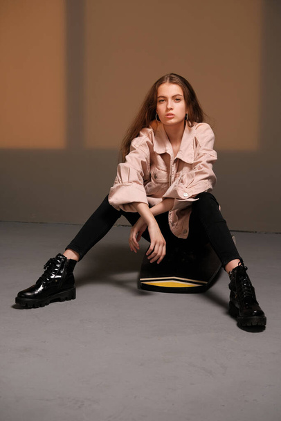 Girl sitting on a balance board and posing. Fashion photography concept - Foto, afbeelding