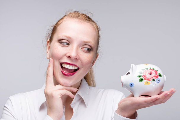 Mladá šťastná žena s prasátko banka / porcelán banka  - Fotografie, Obrázek