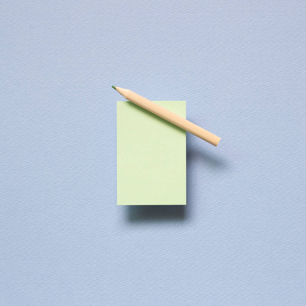 Green memo paper, sticky notes with colored pencil on blue background. top view, copy space - Photo, Image