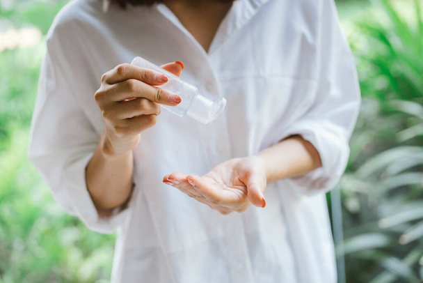 fêmea usando álcool gel anti-séptico para limpar a mão
 - Foto, Imagem