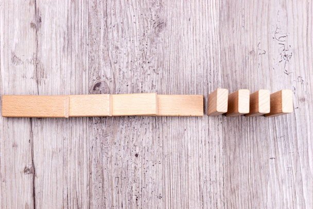 Dominoeffekt. Holzspielzeugklötze auf dem Boden - Foto, Bild
