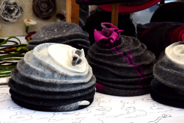 Много различных шляп из войлока на стенде
 - Фото, изображение