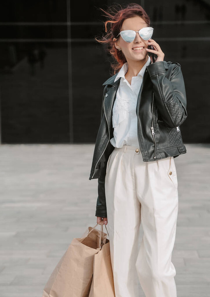 Женщина в кожаной куртке с мобильным телефоном
.  - Фото, изображение