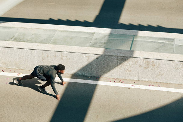 Junge, fitte Marathonläuferin steht in Startposition auf der Straße laufbereit, Blick von oben - Foto, Bild