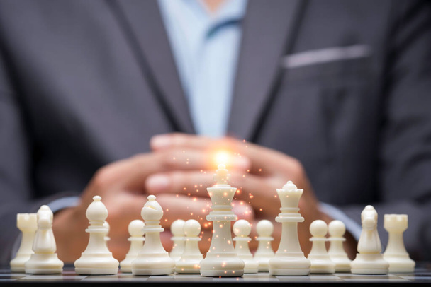 ビジネスマンは計画戦略を考えるために群衆のチェスの数字の後ろに手を分類しました。競争と事業計画と戦略的ビジネス戦略. - 写真・画像