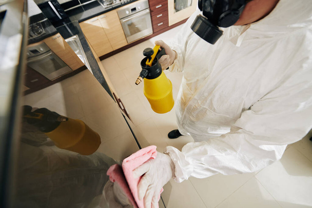 Specialist in hazmat suit cleaning and disinfecting house of client due to coronavirus outbreak - Photo, image