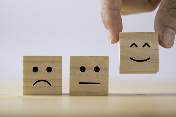 Ruční uvedení smajlíka emoce mezi normální a smutné emoce, které tisknout obrazovku na dřevěné krychle. Průzkum zkušeností zákazníků a koncept zpětné vazby spokojenosti. - Fotografie, Obrázek