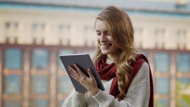 A közeli lány üzeneteket gépel táblagéppel a szabadban. Nő csevegés tabletta - Fotó, kép