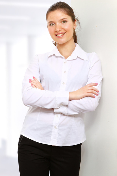 A businesswoman standing near the wall indoors - Photo, image