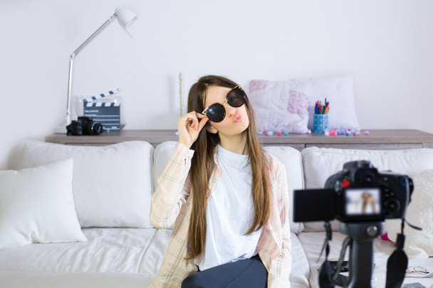 Teen blogger testing sunglasses, broadcasting live videos on social networks. Focus on teen girls influencer bloggers. Beauty bloggers and vlog concept. - Photo, Image