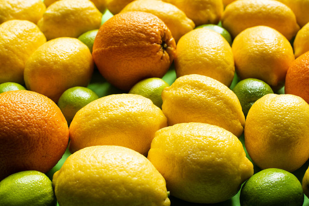 κοντινή προβολή φρέσκων ώριμων λεμονιών, πορτοκαλιών και γλυκολέμονων - Φωτογραφία, εικόνα