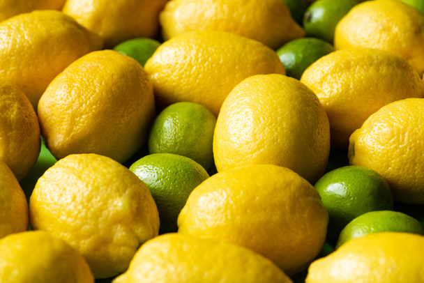 close up view of fresh ripe lemons and limes - Foto, Bild