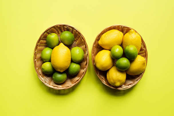 felső nézet érett lime és citrom fonott kosarak színes háttér - Fotó, kép