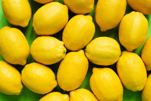 vista superior de limones amarillos maduros sobre fondo verde
 - Foto, Imagen