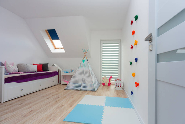 Children playroom with climbing wall and a tent - Foto, imagen