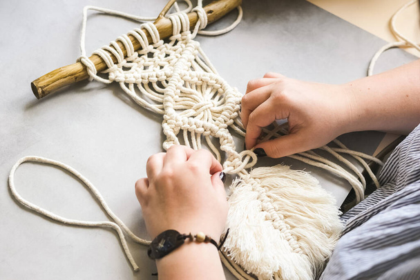 Female hands weave macrame in the home workshop. Boho lifestyle. Hobby hobby concept. Selective focus horizontal frame. - Photo, Image