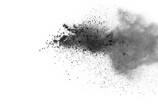 partículas de carbón vegetal sobre fondo blanco, polvo abstracto salpicado sobre fondo blanco, congelar el movimiento del polvo negro explotando o lanzando polvo negro. - Foto, imagen