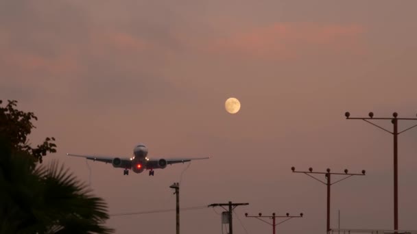 Самолёт приземляется в аэропорту Лос-Анджелеса, штат Калифорния, США. Силуэт пассажирского или грузового самолета, драматический облачный пейзаж. Прибытие самолета на аэродром. Международные перевозки - Кадры, видео