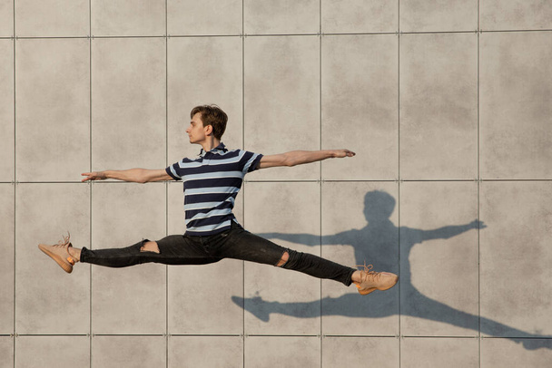Jumping young buinessman in front of buildings, on the run in jump high - 写真・画像