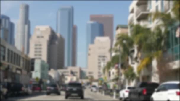 Los Angeles, Kaliforniya 'nın şehir merkezindeki caddelerde araba sürüyorum. Garaj yolundaki arabanın ön camından odaklı olmayan görüntü. Hollywood 'da araçları olan bulanık bir yol. Kamera otomobilin içinde, LA şehri estetiği. - Video, Çekim