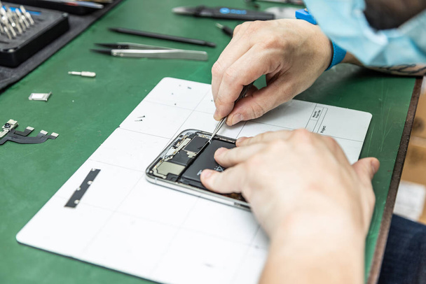 unrecognizable technician repairing smart phone in his repair shop - Фото, изображение