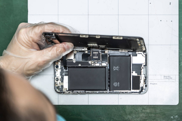 unrecognizable technician repairing smart phone in his repair shop - Foto, Imagem