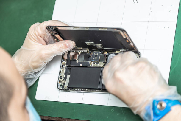 technicien méconnaissable réparer téléphone intelligent dans son atelier de réparation - Photo, image