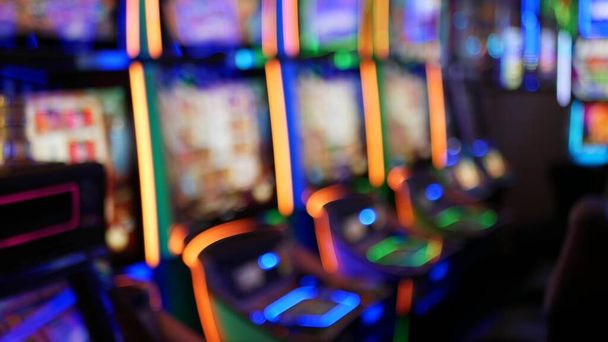 Rozproszone automaty świecą w kasynie na bajecznym Las Vegas Strip, USA. Niewyraźne automaty do gier hazardowych w hotelu niedaleko Fremont Street. Oświetlona neonowa maszyna do gier i zakładów na pieniądze ryzyka. - Zdjęcie, obraz