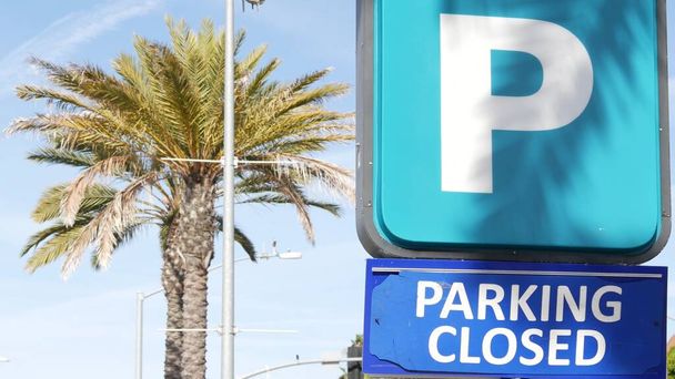 Parking lot sign as symbol of traffic difficulties and transportation issues in busy urban areas of USA. Public paid parking zone in downtown of San Diego, California. Limited space for cars in city. - Photo, Image