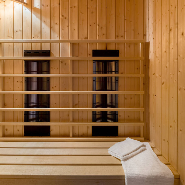 Close-up on finnish style sauna interior with bright conifer wood and ceiling lights on - Foto, Bild