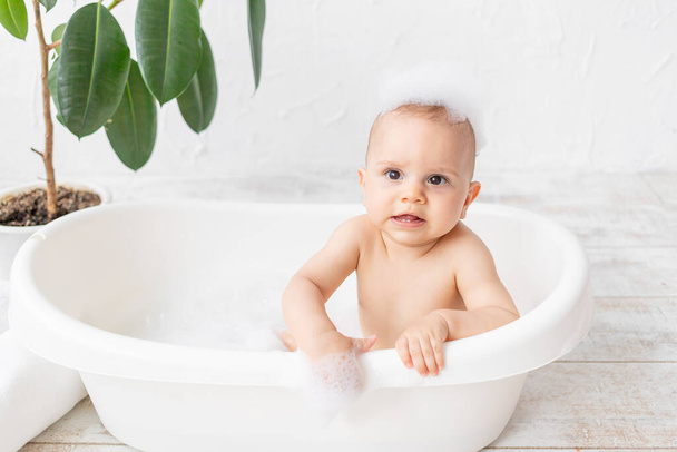 泡とシャボン玉付きの風呂で8ヶ月の小さな子供の男の子、テキストのための場所 - 写真・画像