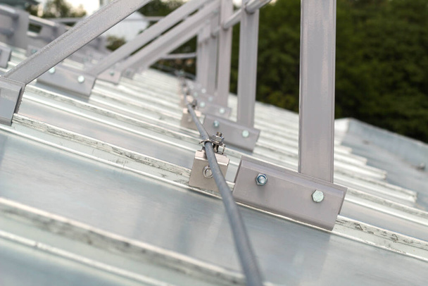 Elementi di fissaggio della recinzione del tetto, morsetti in acciaio installati sul tetto zincato. - Foto, immagini
