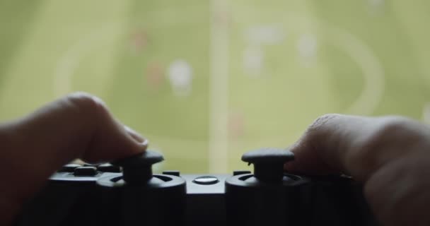 Benutzer, der ein Fußballvideospiel mit einem Steuerknüppel-Controller auf einem großen Bildschirm einer Spielekonsole spielt - Filmmaterial, Video