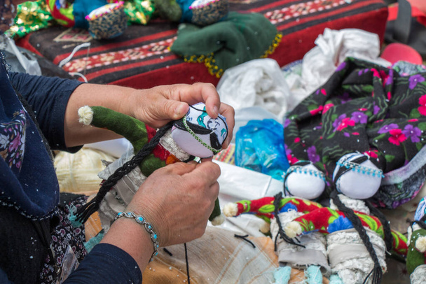 Mujer haciendo muñecas de tela hechas a mano artesanía souvenir - Foto, imagen