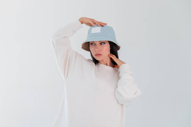 Sports girl in white loCopy spacego sweatshirt. Woman in denim hat. beautiful brunette. - Foto, afbeelding
